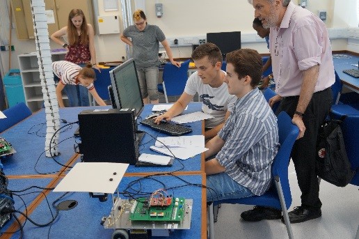 Students sat at a computer chatting to an academic