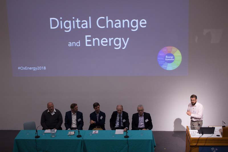 Professor David Wallom presenting at the Oxford Energy Day in 2018, with a panel of experts on stage