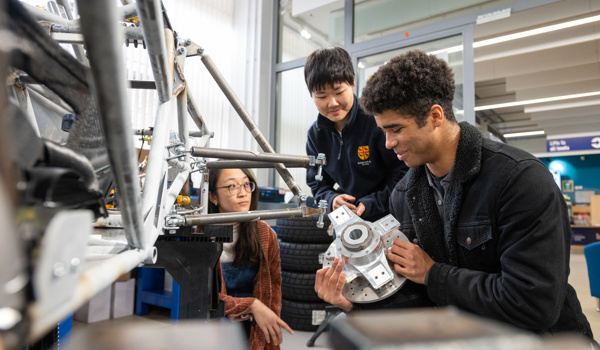 Students looking at parts of the Formula Student car (photo credits John Cairns)