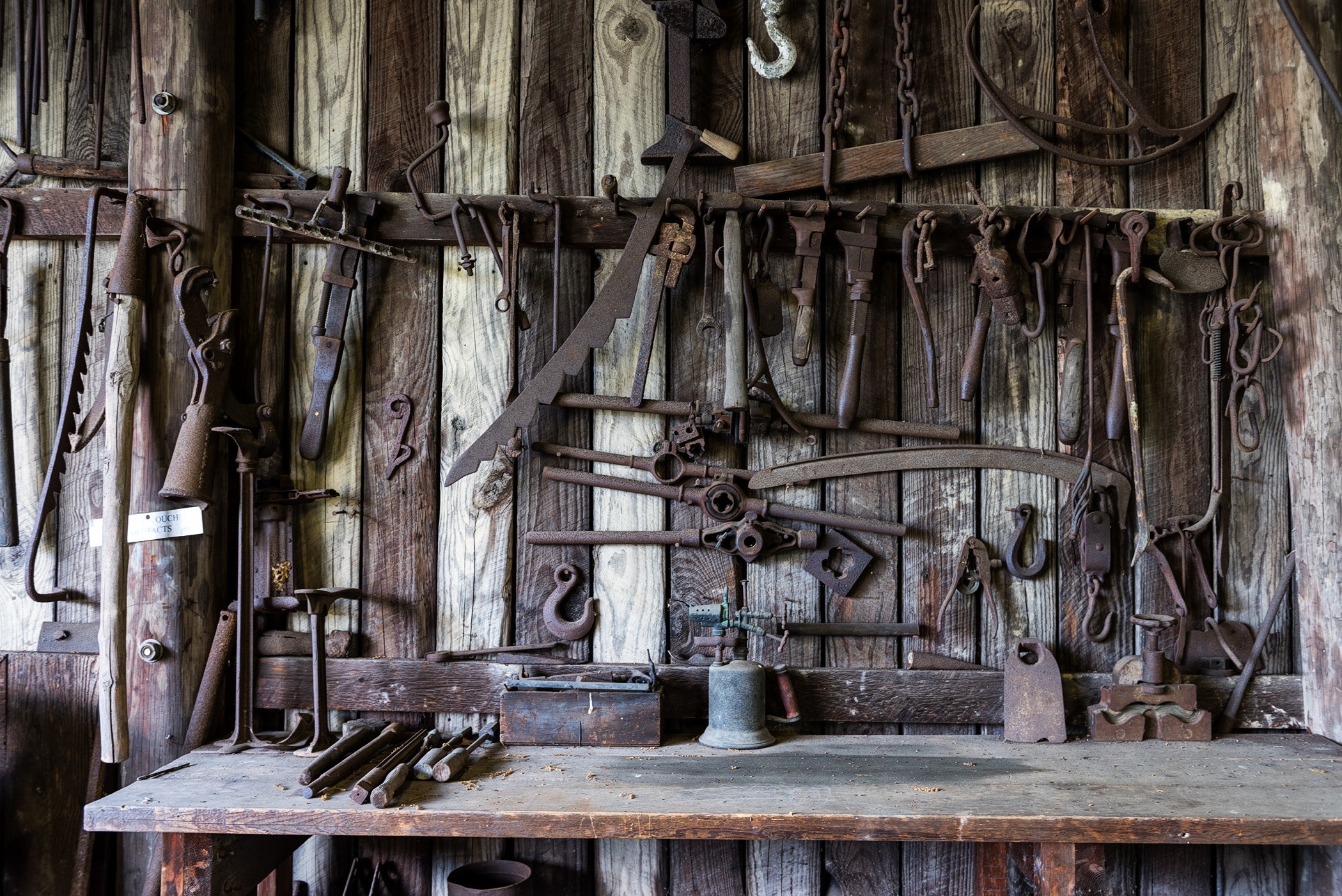 Rusty tools on bench and wall
