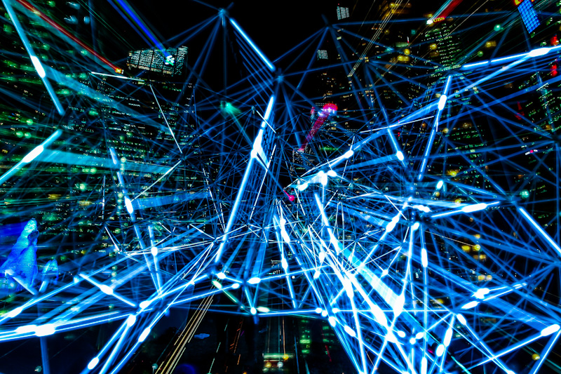 Network of lasers in front of a city scape