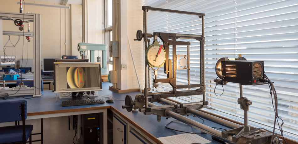 Lamp pointed at glass lens and screen showing light patterns