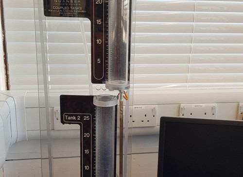 Two small cylindrical water tanks on a desk