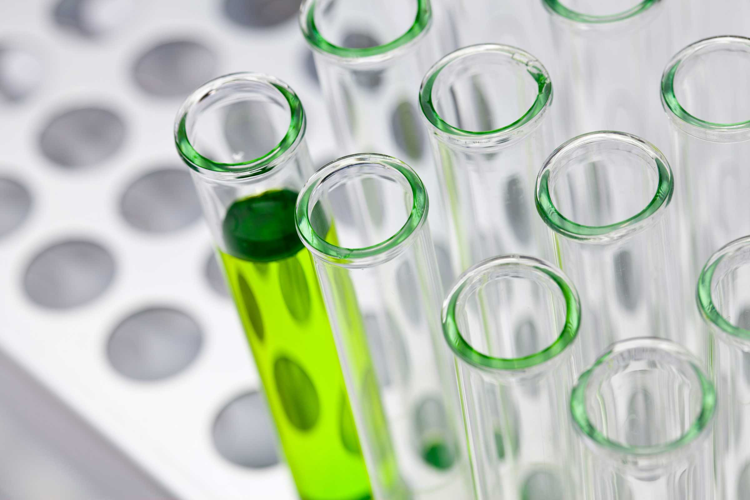 Test tubes, one with green liquid inside