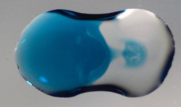 A jet forms between two droplets as they combine.