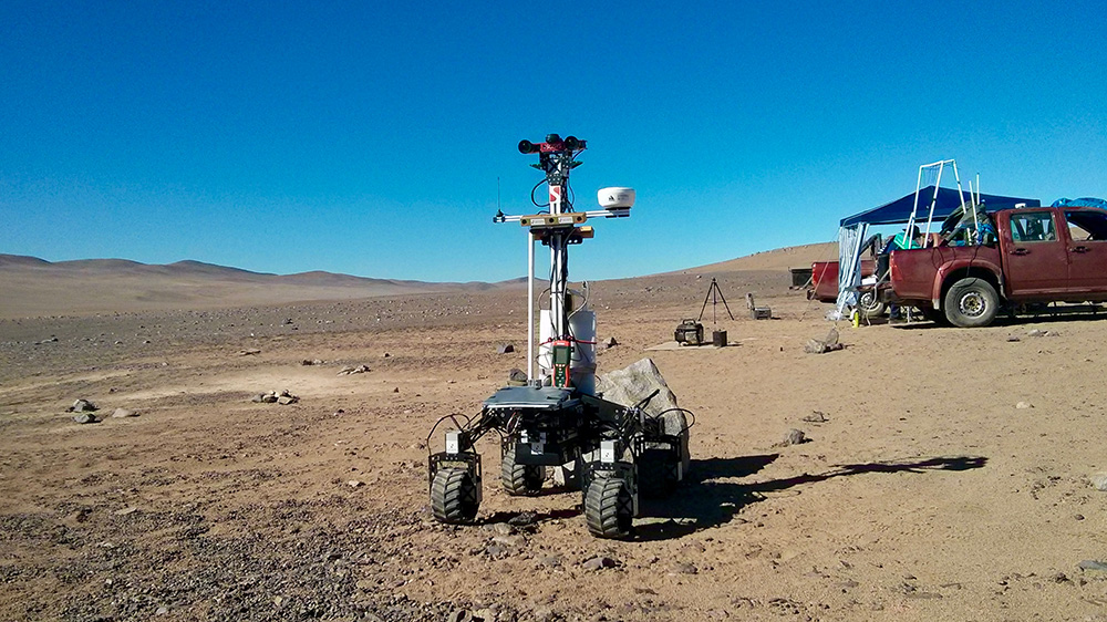 Space rover robot on open plain dirt environment. 