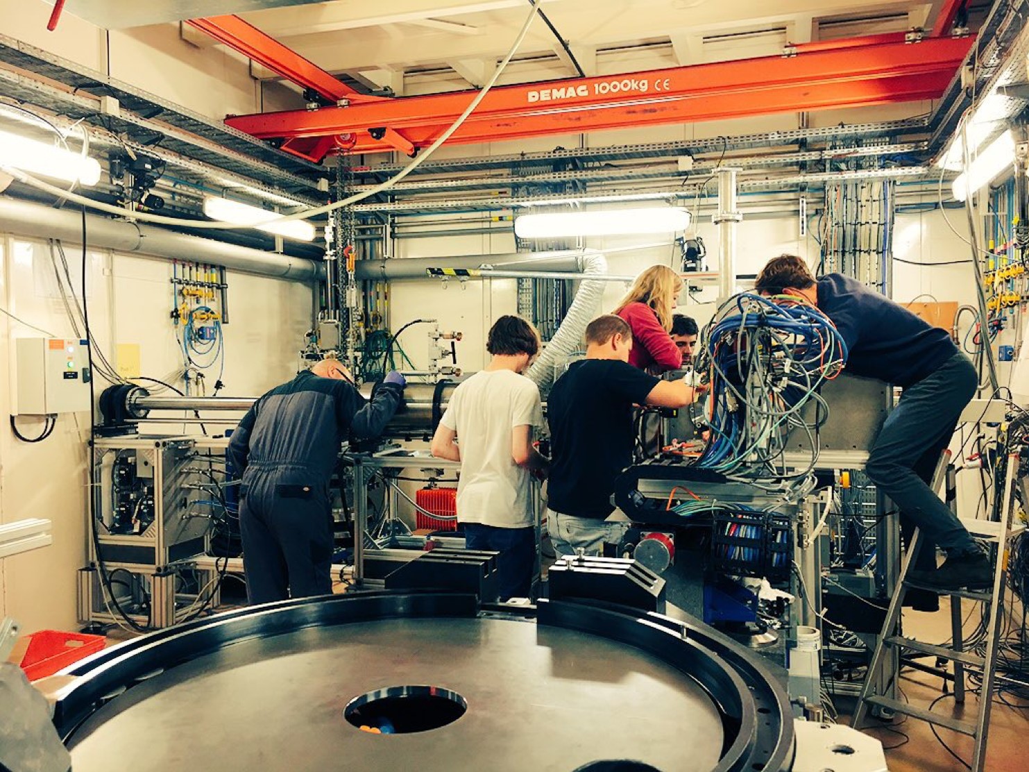 A photo of people working around a large machine in the lab