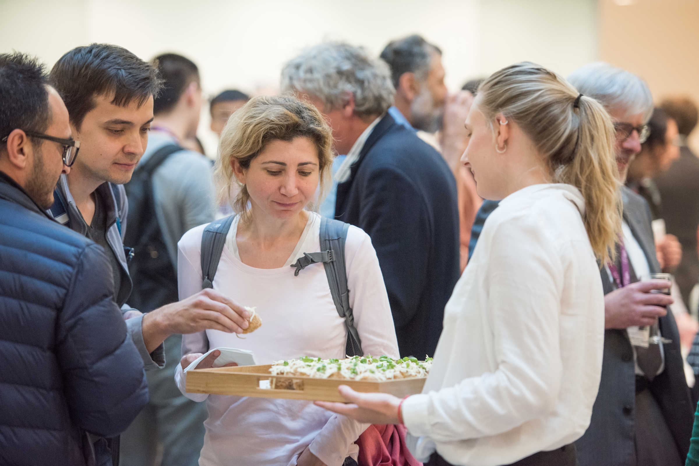 Alumni being served food at an event in the Maths Institute