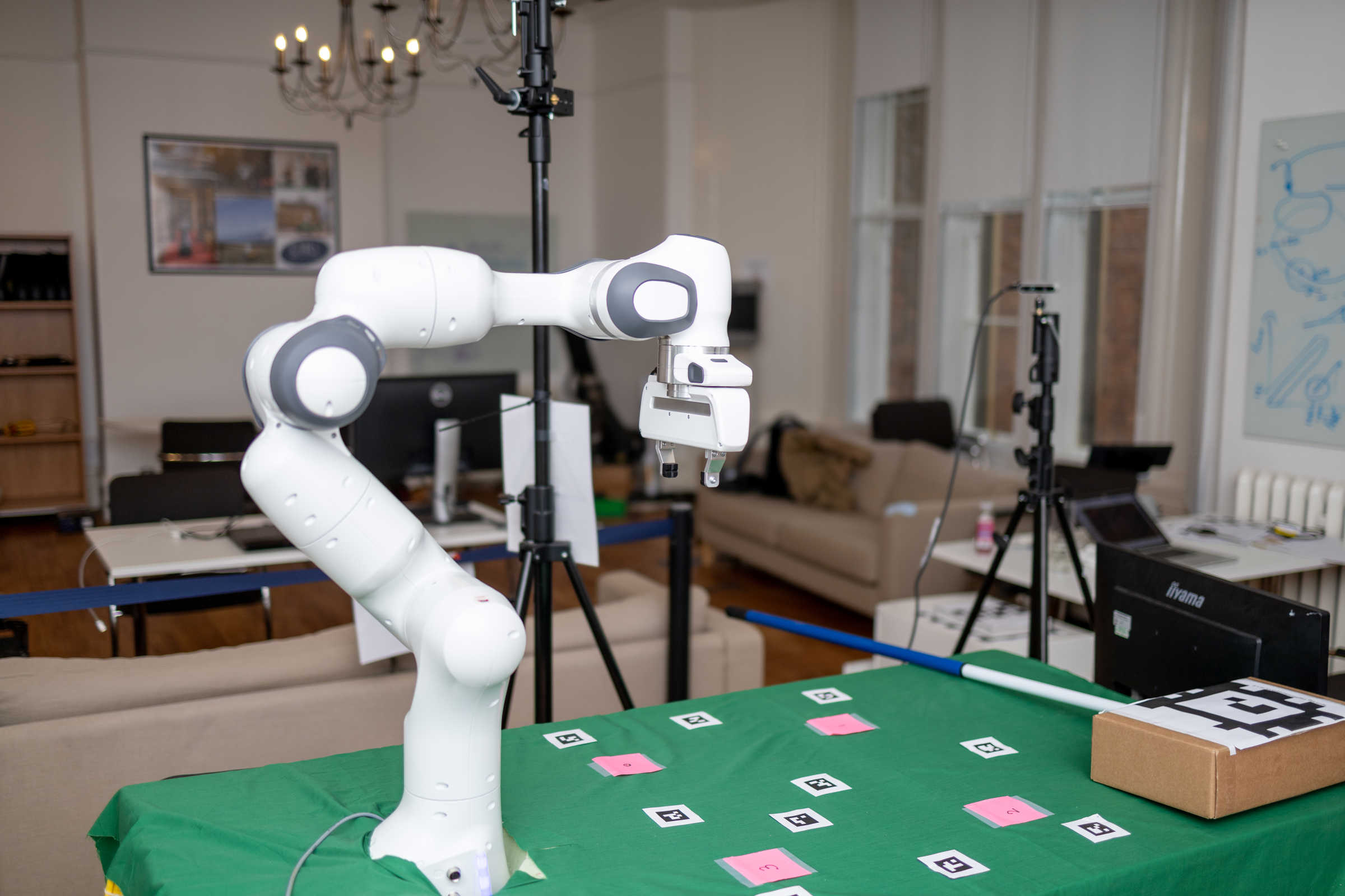 Panda robot arm on green table with cards.  