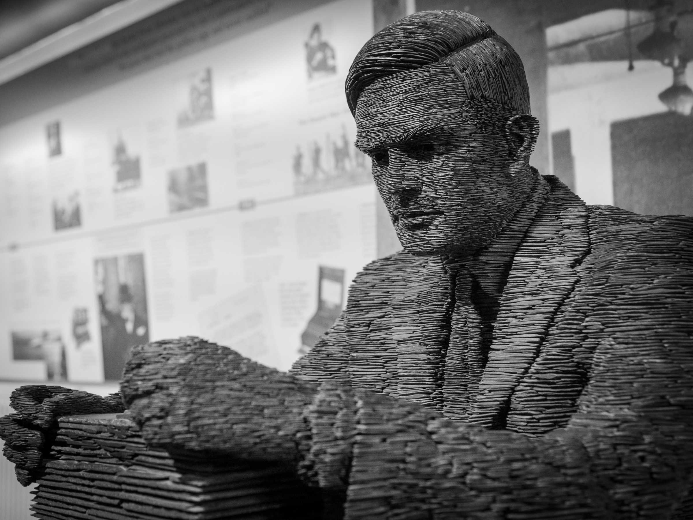 Male sculpture holding pile of papers