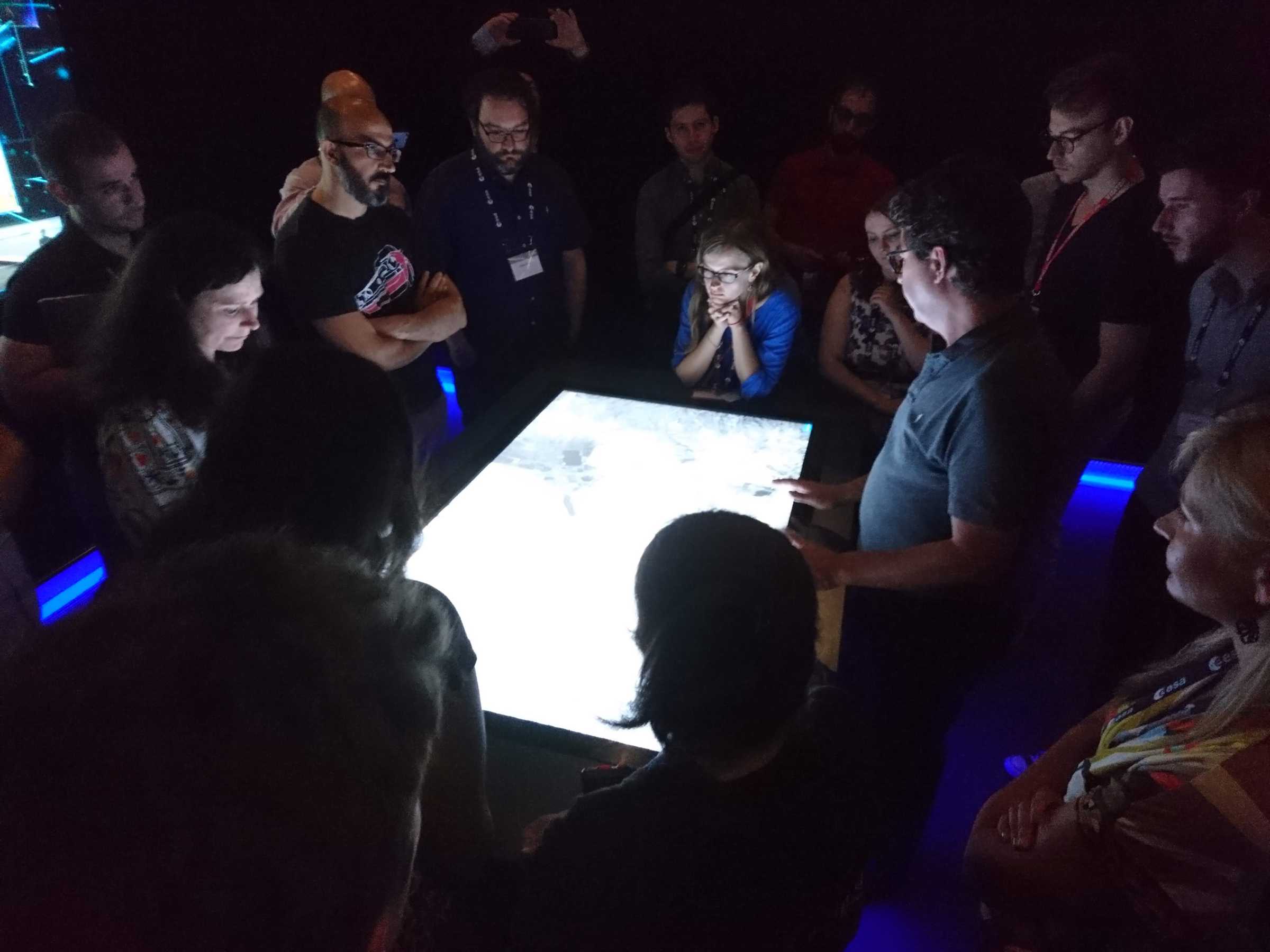 Frontier Development Lab team members looking at images on a lightbox