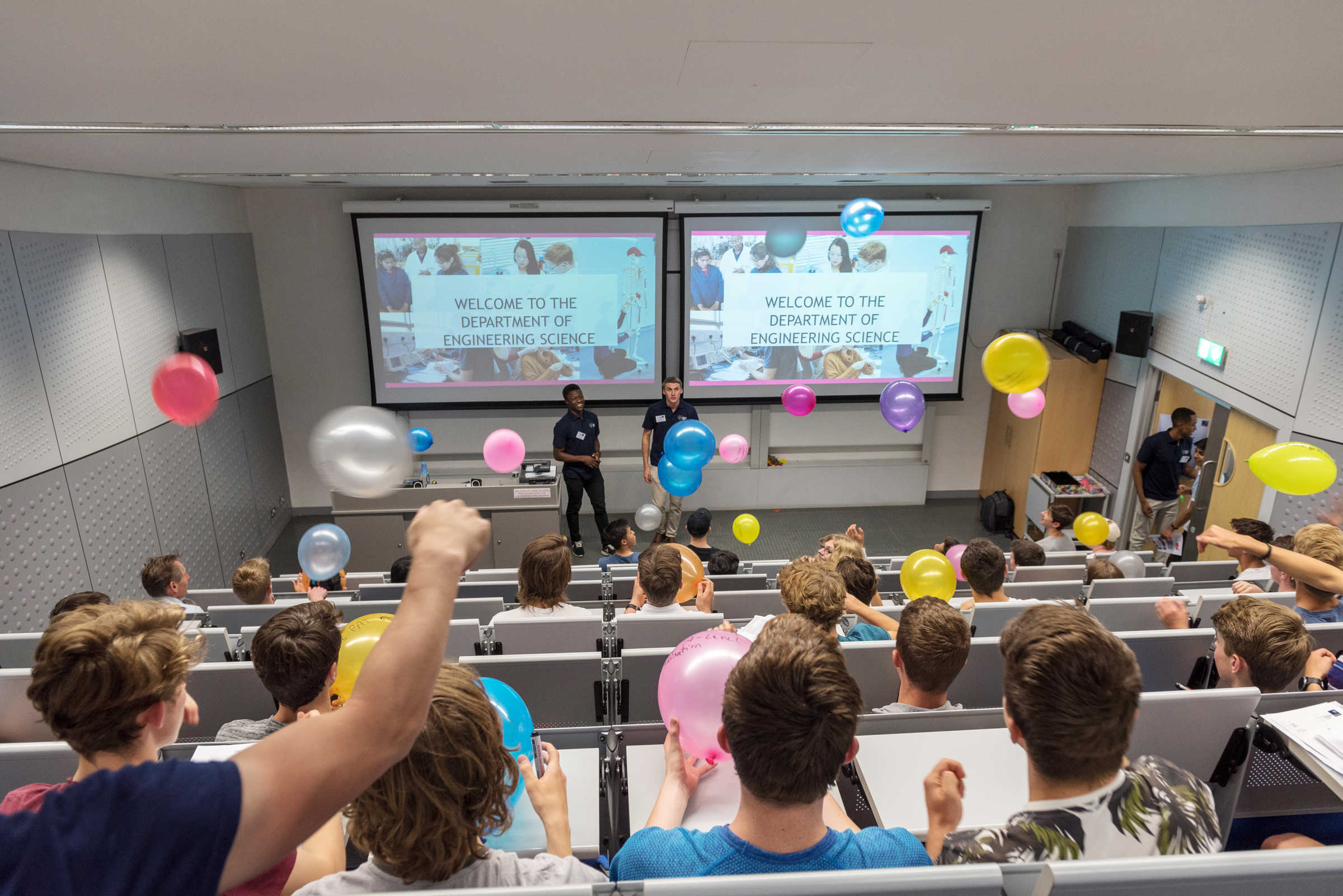 Welcome to the department lecture, with audience throwing colorful balloons
