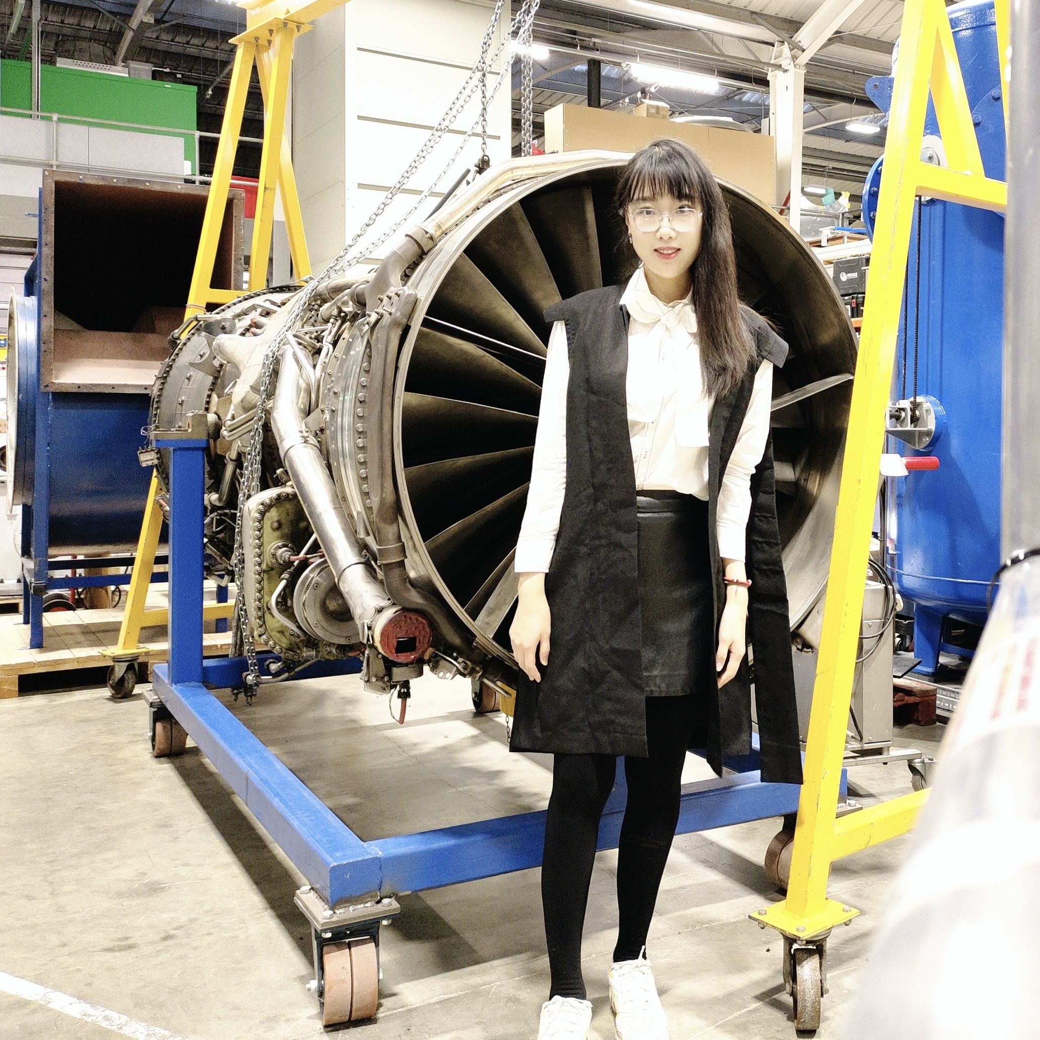 Muting Hao: a photo of Muting, an East Asian woman, standing by a turbine.