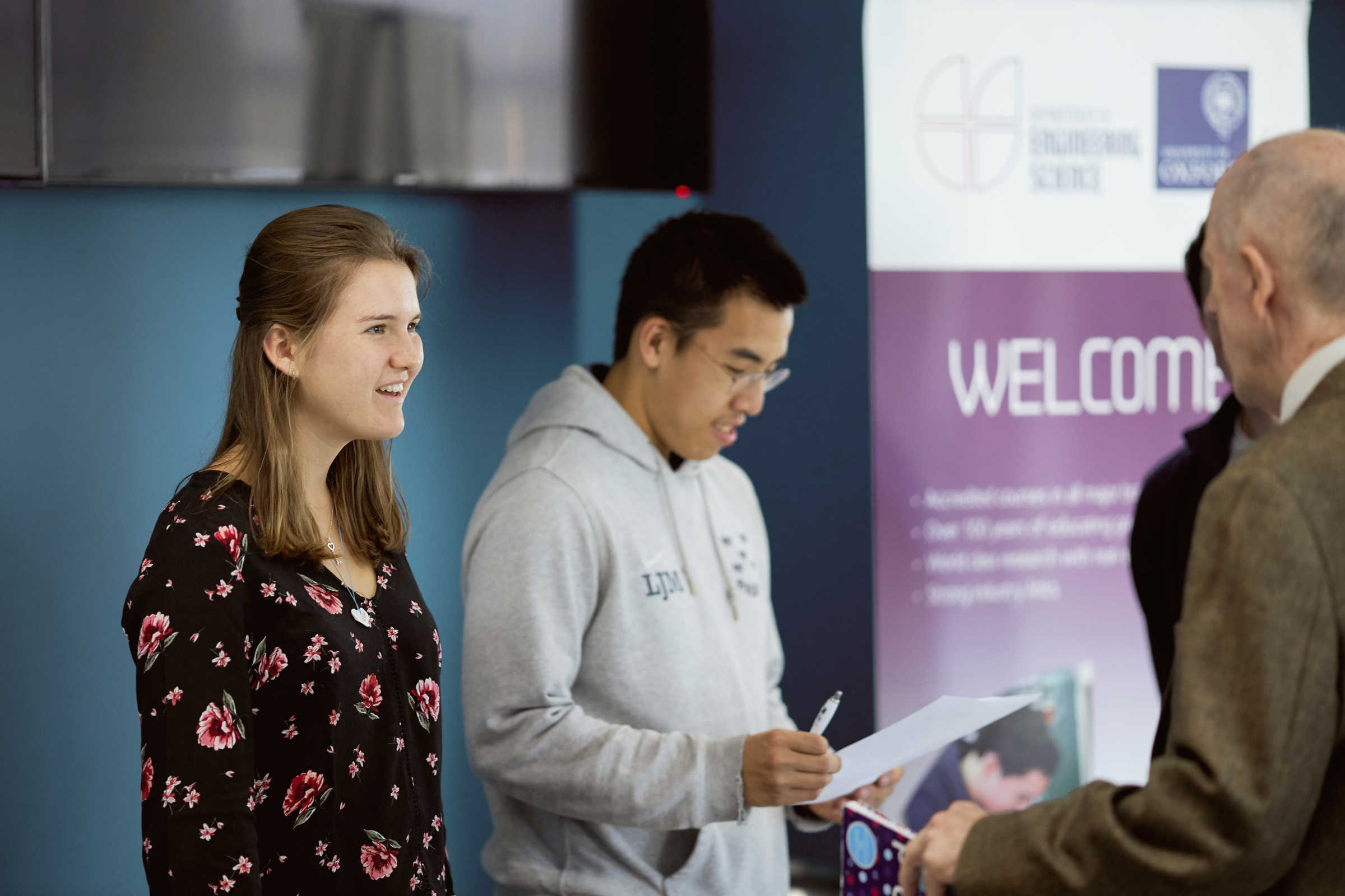 Two student ambassadors greet guests at an event in the Thom Building