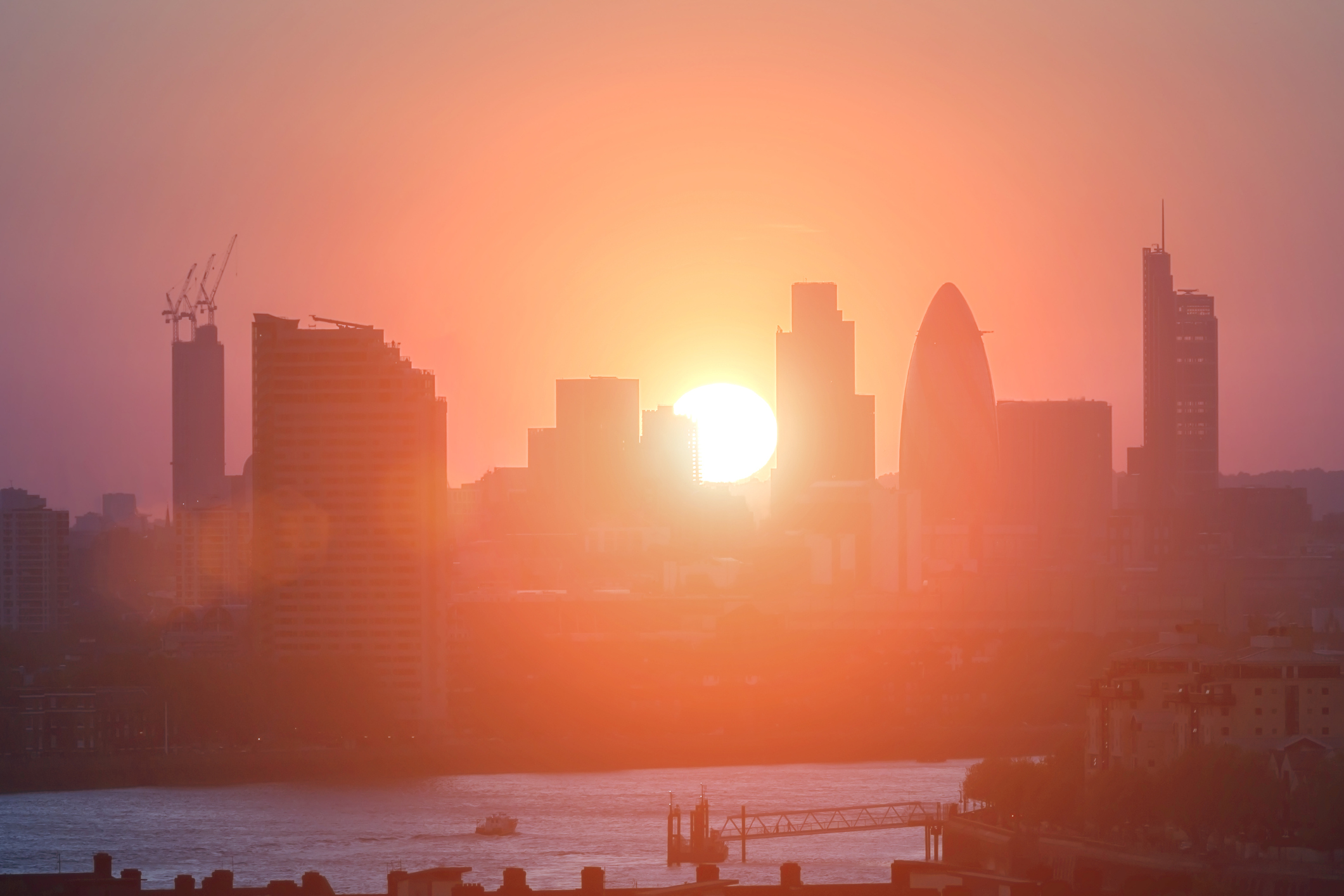 Sun rises over London buildings along the Thames