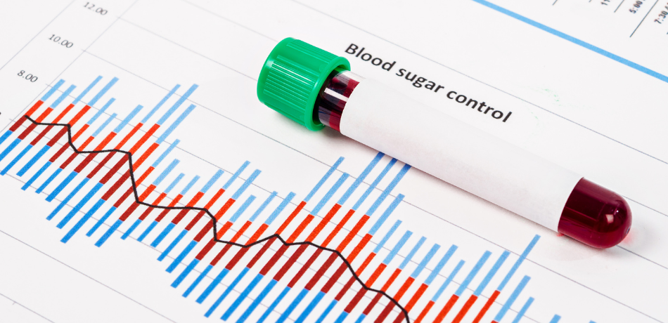 A stock photo of a modern medical blood vial laying on a printed chart tracking blood sugar level.