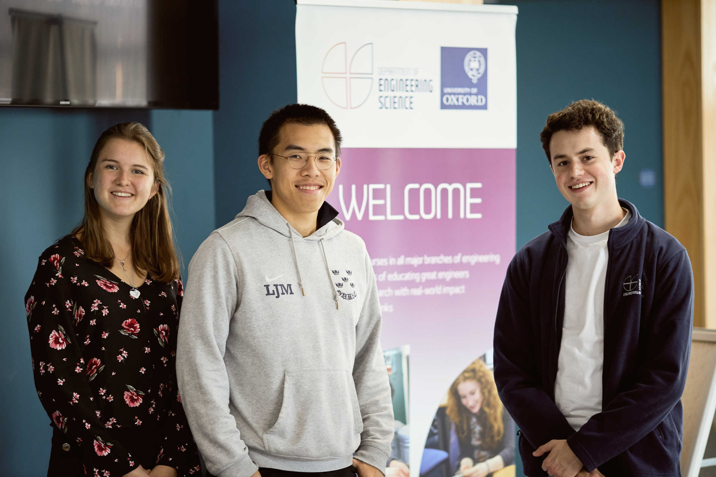 Three students infront of welcome sign