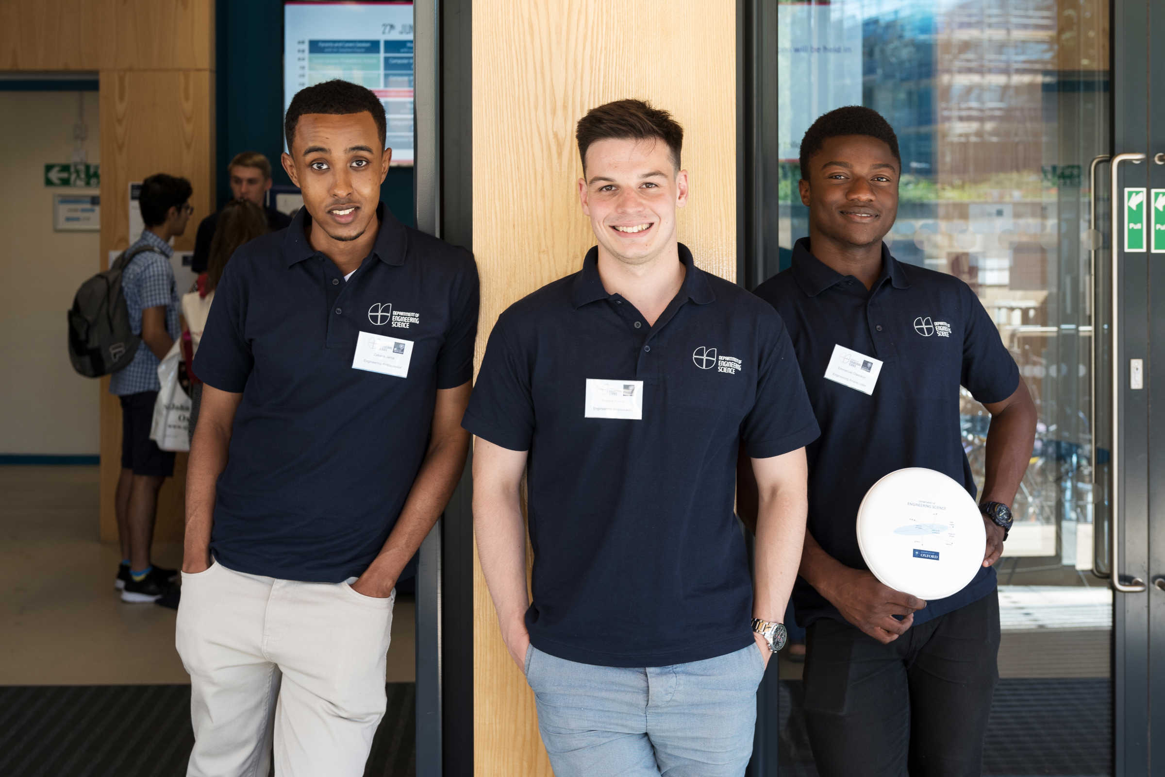 Three student ambassadors stood outside the Thom Building in branded Engineering Science polo shirts